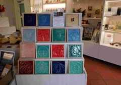 Aufsteller mit bunten Kacheln aus Porzellan mit weiteren Souvenirs im Hintergrund