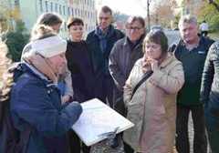Menschen stehen im Halbkreis und schauen auf einen Stadtplan in ihrer Mitte.