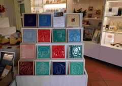 Aufsteller mit bunten Kacheln aus Porzellan mit weiteren Souvenirs im Hintergrund