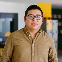 Portrait of a person wearing a green shirt with a look of satisfaction.