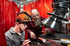 A student and member of staff are welding.