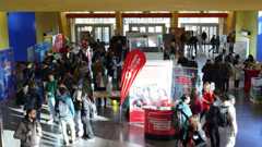 Mehrer Personen stehen in einem Foyer an Messeständen.