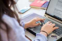 foto de una persona tecleando en un ordenador