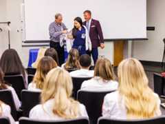 New Radiological Sciences student Michelle Zhang, receives her white coat from Dr. Lee Brown, left and SHRP Dean Jay Garner, during orientation week at the school.