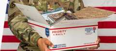 Man in military uniform holding an open package.