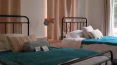 Two beds with pillows and blue covers in El Refugio