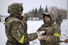 epa09785014 An Ukrainian serviceman gives medical aid to her colleague near the city of Kharkiv, Ukraine, 25 February 2022. Russian troops entered Ukraine on 24 February prompting the country's p ...