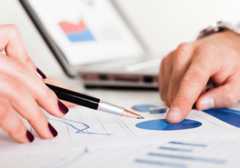 Financial insurance meeting with fingers pointing at graphs