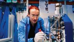 Explore postgraduate study Student studying in a lab wearing a blue lab coat