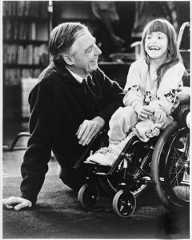 Fred Rogers photographed with a little girl in a wheelchair