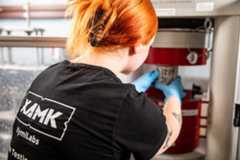 Ihminen on selin kameraan ja tekee töitä laitteella.