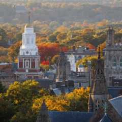 Aerial view of Yale University during autumn showcasing historical architecture with colorful foliage in the background.