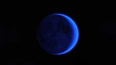 A blue moon in a dark sky.