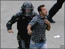 An Iranian man is detained by Iranian riot police in front of Tehran university during post-election protests in Tehran on 14 June