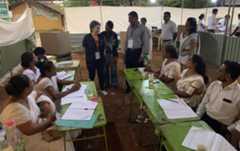 Staff members of the polling station welcome one of the European Parliament's election observers