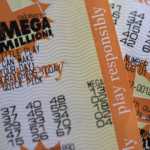 Several orange Mega Millions lottery tickets are pictured.