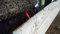 ガードレールにイヤホンをつないでラジオを聞く