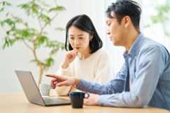 パソコンを見ながら複数社を比較する夫妻のイメージ