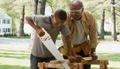 man and grandson wearing eye protection while cutting wood man and grandson wearing eye protection while cutting wood