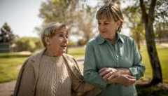 We Need to Talk older woman and mother with locked arms walking and talking outside