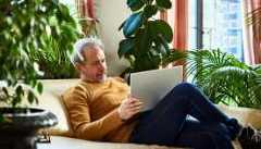 What to know about social security benefits Man with grey hair and beard relaxing on coach in living room with laptop
