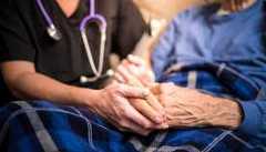 Close up of a hospice nurse holding the hands of one of her patients Close up of a hospice nurse holding the hands of one of her patients