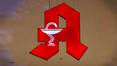 Ein leuchtendes rotes Apotheken-A-Zeichen mit einer weißen Schale und Schlange im Zentrum, passend zum Thema Apotheken-Notdienst.