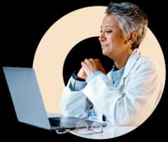 Header image circle min Healthcare professional in lab coat with glasses and laptop.