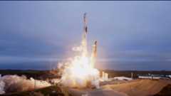 A rocket blasts off against a cloudy sky.