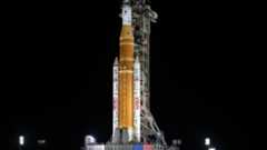 NASA's giant white and tan rocket on the way to the launch pad