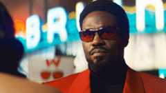 Simon Williams wearing sunglasses and an orange jacket in Wonder Man