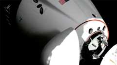 a space capsule is seen docking to a space station in a close-up of its nose section