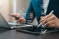 Business performance monitoring concept, businessman using tablet and laptop Online survey filling out, digital form checklist, blue background.