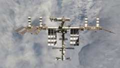 A photo of a large space station with various solar panels floating above Earth.