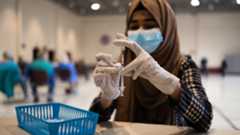 a healthcare worker prepares a vaccine dose