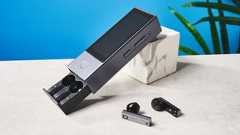 A black and gray Timekettle X1 AI Interpreter Hub translator with earbuds