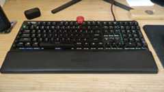 An AOC AGON AGK700 keyboard on a wooden desk