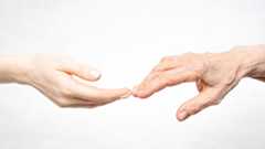 the hands of a young and old woman touch