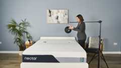 Tester Ruth Jones drops a slam ball on the Nectar Premier Memory Foam Mattress to measure its motion isolation. Two accelerometer are taped to the mattress to measure the ball's initial impact rate.