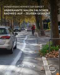 Dieser Alternativtext wurde KI-generiert: Ein Straßenschild warnt vor gefährlicher Verkehrssituation aufgrund falscher Markierungen auf dem Radweg. Im Hintergrund sind Fahrzeuge und Bäume zu sehen.