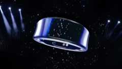 A metallic ring-shaped object is suspended in a dark space with spotlight illumination and a starry background.