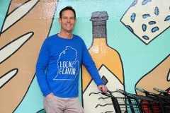 Alan Hartline wears a Local Flavor t-shirt at Kingma's Market entrance.
