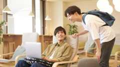 Teacher and student smiling in front of a computer