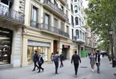 Personas paseando por la zona comercial del Paseo de Gracia en Barcelona.