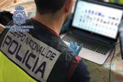 Un policía nacional revisa un ordenador intervenido.