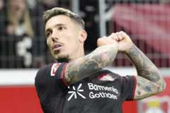 Leverkusen's Alex Grimaldo celebrates after he scored the opening goal during the German Bundesliga soccer match between Bayer Leverkusen and Eintracht Frankfurt at the BayArena in Leverkusen, Germany, Friday, Sept. 12, 2025. (AP Photo/Martin Meissner)