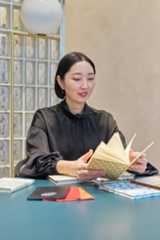 ノートを手に取ってめくる山内マリコ