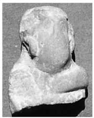 Figure 9. Old Termez. Terracotta figurine with representation of a warrior, second—first centuries BC. We have thus examined some of the figures on the Khalchayan reliefs. Others— with a demonic expression and a very distinctive hairstyle with long side-whiskers—are paralleled in terracotta plastic art. We have at present several images resembling the fig- ures of Khalchayan. One of them was found in a second to first century BC layer at the site of Old Termez (Fig. 9). It is a moulded yellow clay figure in high relief with a flat back, representing a male head with large ringlets and long whiskers, originally misidentified by the excavator as a female (Pidaev 1987, 89). There are vertical lines clearly identifiable as chain-mail armour on the neck.