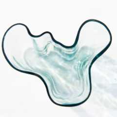 A light-blue decorative glass bowl sits on a white surface.
