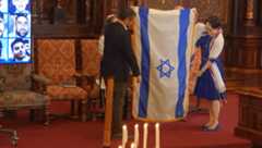 Rabbi Angela Buchdahl and Dagan Shimoni fold the Israeli flag that had been displayed on Central Synagogue's bimah since the attacks of Oct. 7, 2023.